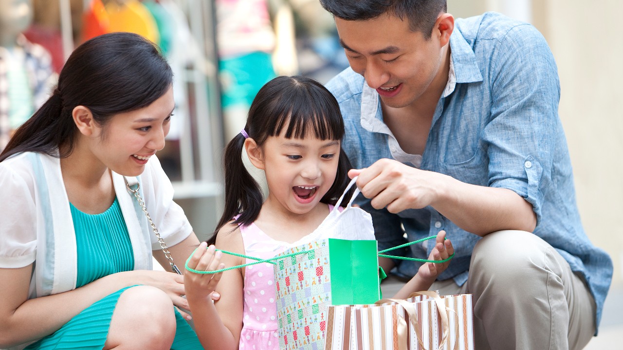 A girl is checking out the gift box; image used for HSBC Red Hot Rewards.